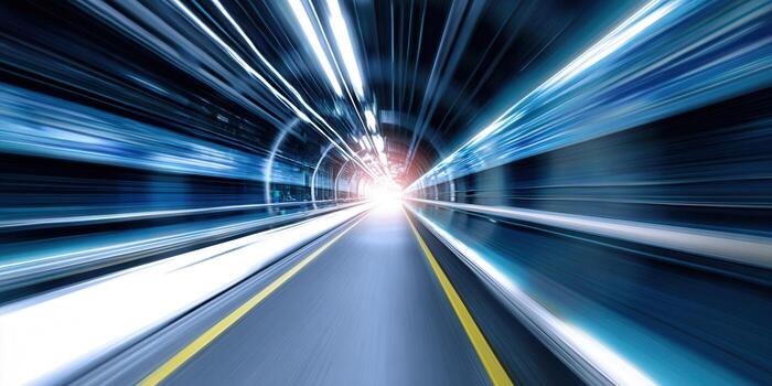 The image captures a dynamic tunnel with streaks of light, emphasizing speed, and a forward perspective. photo