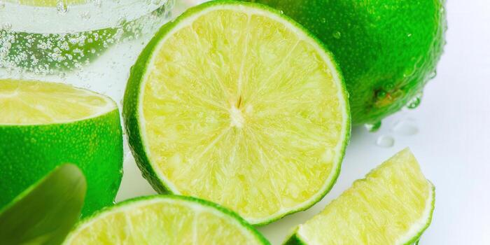 Vibrant green limes, sliced and ready to enjoy, with refreshing water droplets on a white background. photo
