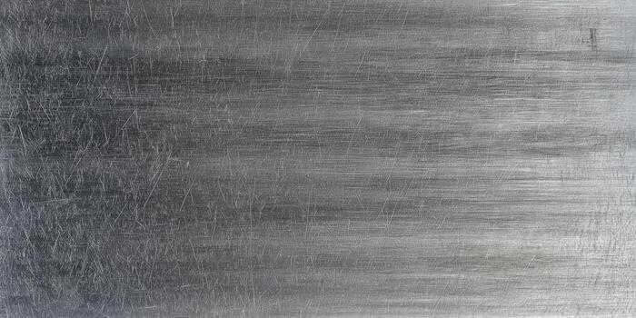 A close-up of a textured metal surface showing scratches and an industrial look. photo