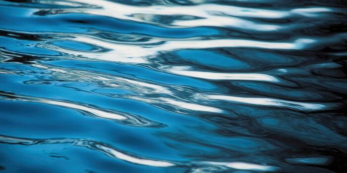 Blue water ripples create a mesmerizing abstract pattern reflecting light and movement. photo