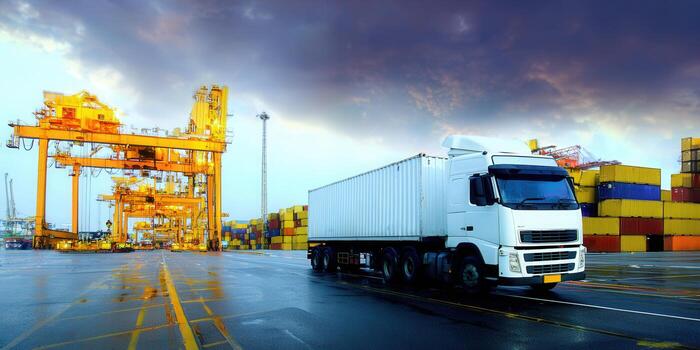 A white semi-truck and container at a shipping port, transporting goods globally. photo