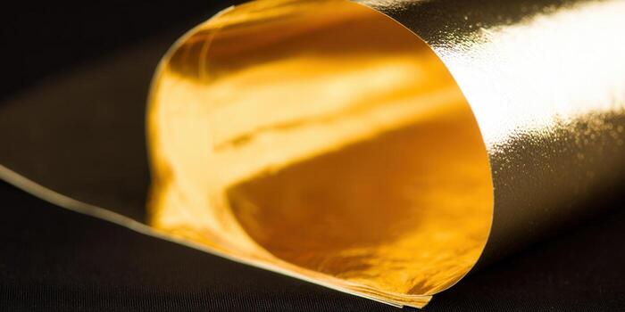 Close-up of a golden, rolled paper with a shiny, reflective surface. photo