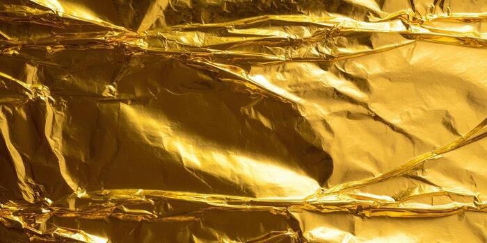 A detailed image of crumpled gold foil with a bright, shiny surface reflecting light. photo