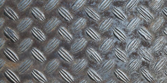 Close-up view of a metal diamond plate, featuring a textured surface and repeating pattern. photo