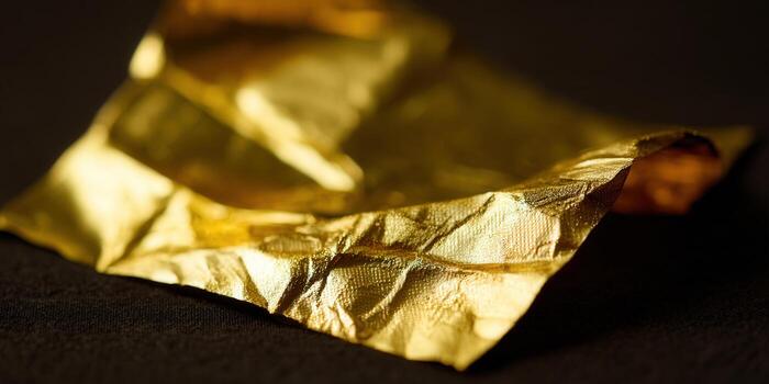 A textured sheet of gold leaf shimmers, creating a luxurious abstract composition photo
