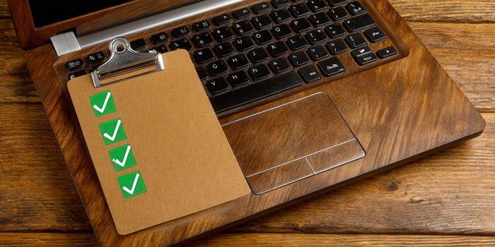 Clipboard with checkmarks on a laptop, symbolizing tasks and completion. photo