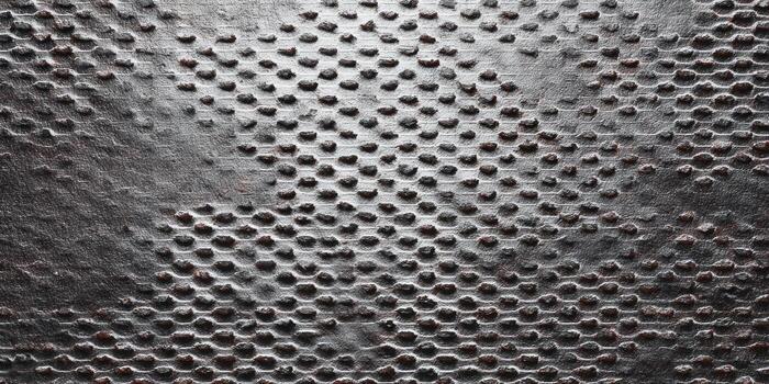Abstract metal surface with a repetitive geometric pattern and textured detail. photo