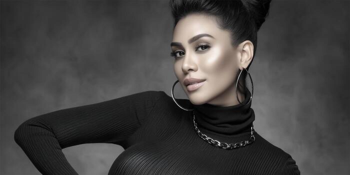 Elegant woman with hoop earrings and turtleneck posing in a studio setting. photo