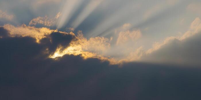 Golden sunlight beams through the clouds, creating a beautiful, dramatic sky scene. photo
