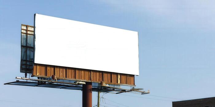 A large, empty billboard provides plenty of space for advertising in a bright, blue sky setting. photo