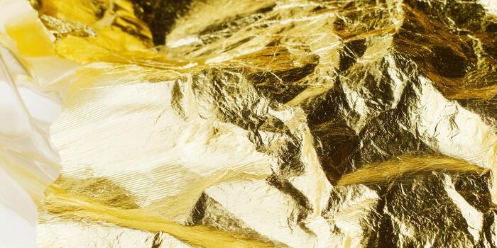 Close-up of elegant, textured gold leaf with detailed highlights and shadows. photo