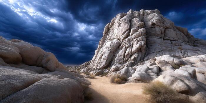 A striking desert scene features large rock formations and a dark, stormy sky overhead. photo