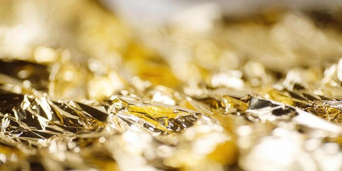 Golden foil background texture shows metallic details and reflections. photo