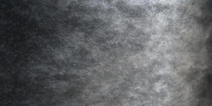 A dark textured surface with scratches and metallic appearance creates an industrial and elegant backdrop. photo