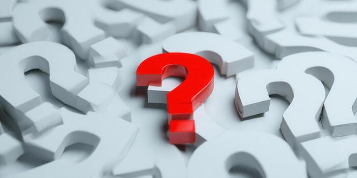 A bright red question mark stands out among many white question marks. photo