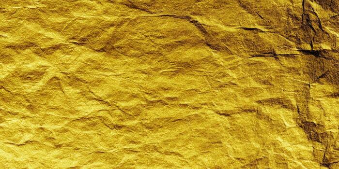 A close-up of a golden, textured paper with a wrinkled appearance, perfect for backgrounds. photo