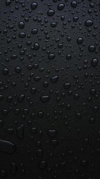 Abstract background featuring a dense collection of small water droplets on a deep black textured surface photo