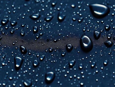 Detailed texture of a dark blue surface covered with small and large water droplets, creating a visually appealing abstract composition photo