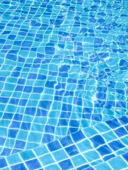 Sparkling Blue Swimming Pool Water with Sunlight Reflections Creating a Mesmerizing Pattern of Waves and Grids photo