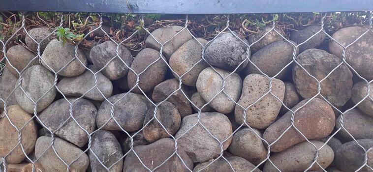 River Rock Retaining Wall with Wire Netting photo