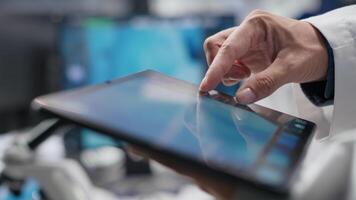 Close up of tablet with modern laboratory software used by scientist for a science experiment, advanced tech. Focused on molecular biology, biotechnology and healthcare innovation. Camera B. video