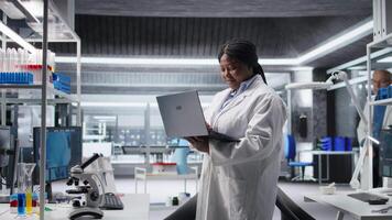 porträtt av forskare på arbete i en kemi labb omgiven förbi verktyg och Avancerad tech. ledande en forskning studie för biokemi, nanoteknologi och diagnostik, framtida upptäckt. kamera a. video