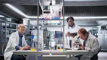 team av experter undersöka molekyl prover på mikroskop med laboratorium bricka och lins systemet, förstoring verktyg Stöd diagnostik och bioteknik genombrott i vetenskap. kamera a. video