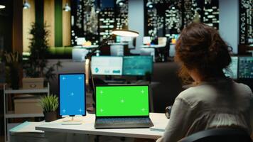 Business consultant works with mockup copy space on tablet and laptop, researching reports for a management project. Collecting information and solving tasks late at night, work after hours. Camera A. video