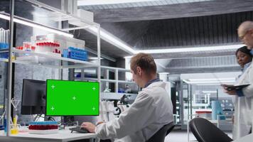 Mockup on desktop next to scientist conducting professional analysis in chemistry lab, experiment data for molecular science. Advanced research, pharmacology and biotechnology discovery. Camera A. video