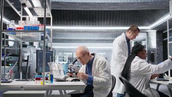 masculino investigador às microscópio análises biociência amostras a partir de laboratório bandeja. foco em celular observação e detalhado molecular estude enfatiza a científico método, bioquímica e dados análise. Câmera uma. video