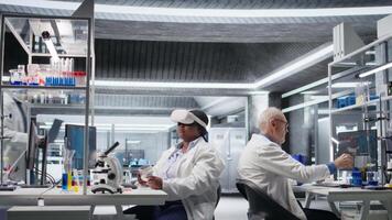 donna esperto nel laboratorio utilizzando vr cuffia per simulare sperimentare e ricerca studia. virtuale la realtà Tech supporto microbiologia e Avanzate medico scoperta nel assistenza sanitaria. telecamera un. video