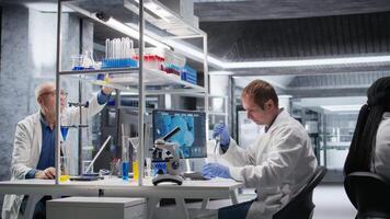 forskare användningar pipett till överföra liten droppe av prov in i burk under experimentera i de laboratorium. exakt procedur highlighting bioteknik forskning, molekyl biologi och innovation. kamera a. video