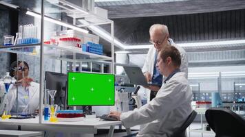 Green screen on computer display with colleagues working in biotechnology lab, using laboratory analysis, bioengineering and healthcare technology. Progress in pharmaceutical science. Camera A. video