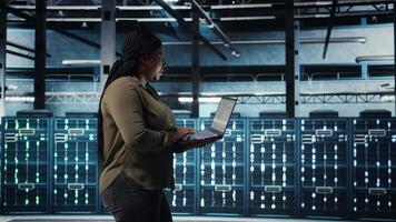 software desarrollador en datos centrar utilizando ordenador portátil a coordinar despliegue de nuevo servidor arquitectura. servidor cubo eso profesional utilizando cuaderno a hacer desenrollar de la seguridad cibernética estructura, cámara un video