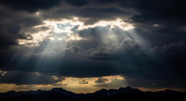 Sunbeams shining through clouds over mountains photo