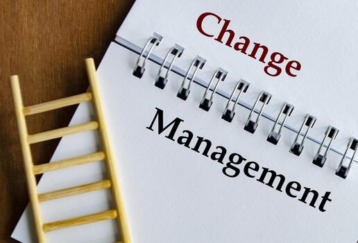 Notepad displaying Change Management in bold text with ladder on wooden surface. photo