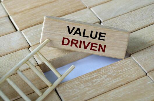 Value driven text written on wooden blocks stacked on a ladder highlighting the importance of core organizational principles. photo