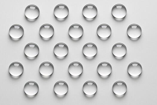 Off white background with arranged transparent droplets in precise symmetrical rows. photo