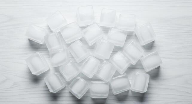 Pile of ice cubes on a white wooden surface, perfect for cooling drinks and refreshing beverages photo