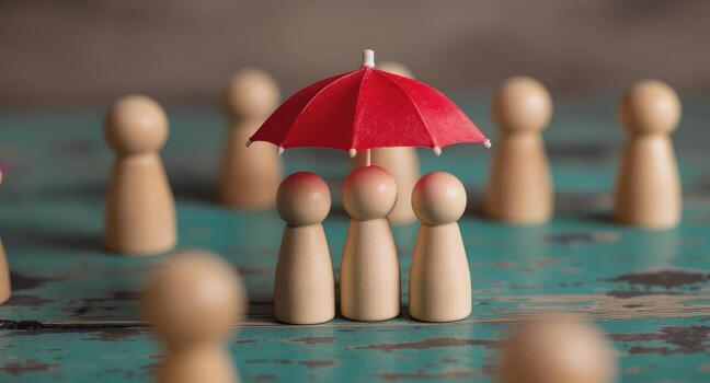 Wooden figures under a red umbrella symbolizing protection and security on a textured surface setting scene photo