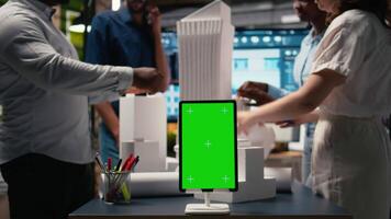 ingenjörer team dela med sig bemästra planen idéer Nästa till krom nyckel visa, använder sig av 3d arkitektonisk modeller och ritningar för konstruktion layout detaljer. modern design stad planera i en session. kamera a. video