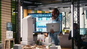 afrikansk amerikan utvecklare använder sig av modern design programvara till skapa en syn för en urban infrastruktur, fokusera på fast egendom konstruktion och bostads- område planera. innovation nav. kamera a. video