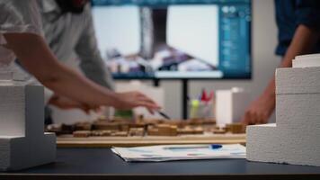 Close up of developers work together on layout city planning initiative with residential project for infrastructure growth, experts using 3D models for site preparation. Master plan. Camera A. video
