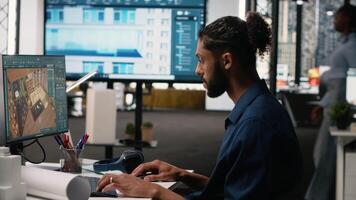 mitten östra manlig utvecklare skapande fast egendom layout med möbel och Övrig strukturera detaljer, interiör design på dator. arbetssätt på sanering för en bostads- konstruktion. kamera b. video