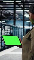 Vertikale Daten Center Programmierer Verwendet Grün Bildschirm Tablette zu sich entwickeln Katastrophe Wiederherstellung Pläne, Minimieren Ausfallzeit. es Experte im Server Bauernhof, verbessern Daten Schutz Protokolle mit Chroma Schlüssel Gerät, Kamera ein video