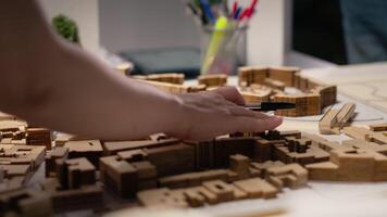 Close up of urban developers showing master plan for residential layout project, using 3D models on table to present idea of a smart city. Site preparation for infrastructure growth. Camera B. video