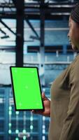 vertical datos centrar especialista monitores datos centrar métrica en verde pantalla tableta a mejorar Operacional eficacia. servidor habitación trabajador usos analítica en croma llave dispositivo a predecir actuación, cámara un video