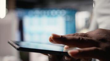 afrikansk amerikan utvecklare utvärdera 3d modeller ritningar och digital programvara som del av strategisk hus projekt i urban utveckling område. stad planera företag projekt på läsplatta. kamera a. video