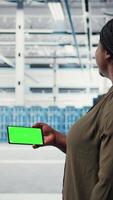 Vertical Server hub system administrator uses green screen smartphone to watch tutorial on how to upgrade rigs. Data center employee following guide on mockup mobile phone to improve speed, camera A video