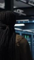 Vertical Programmer overseeing high tech server farm, ensuring compliance with industry standards. Data center IT professional conducts security audits to protect against cyber threats and glitches, camera B video